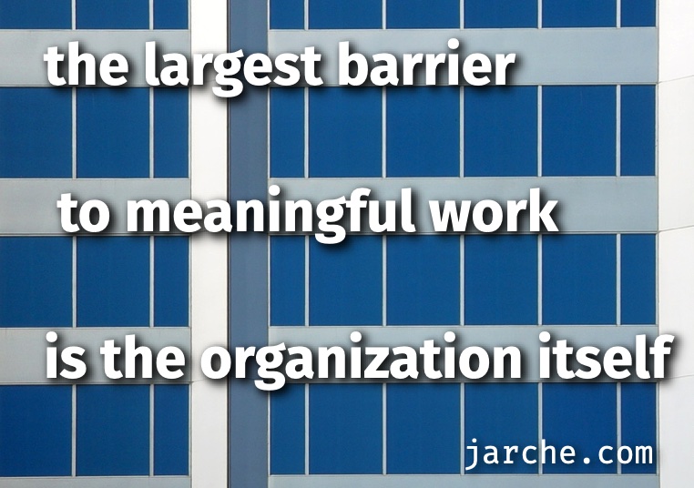the largest barrier to meaningful work is the organization background image: exterior of large office building